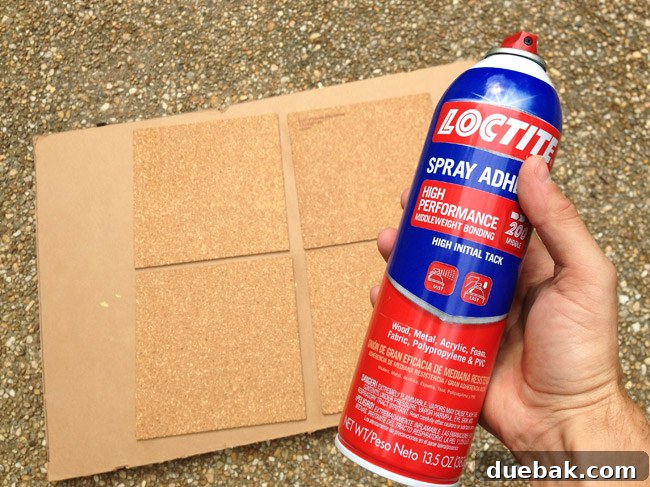spraying loctite spray adhesive on cork board tiles to affix them to cork board wall