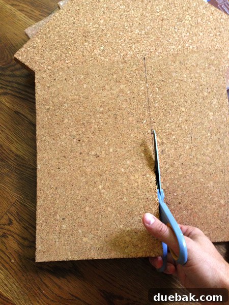 using scissors to cut cork tiles to fit to size on cork board wall