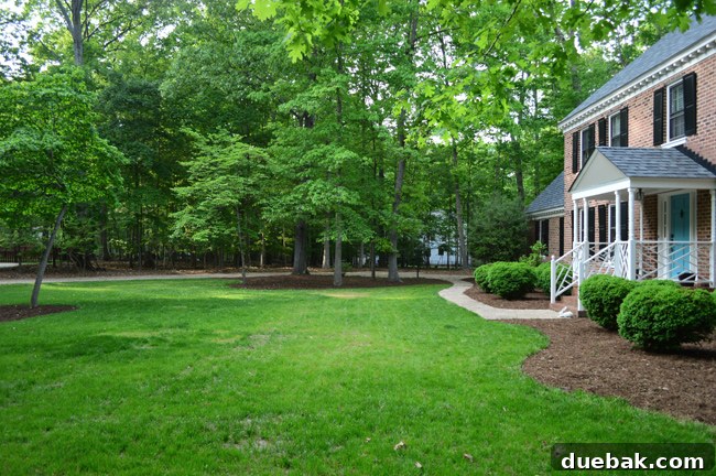 Large Grassy Yard In Front Of Brick Colonial Home
