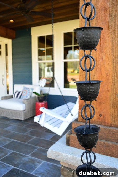 Decorative dark bronze rain chains on the front porch, replacing traditional downspouts.