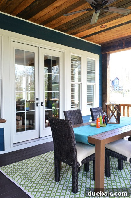 Back porch with exposed wood ceiling and Trex flooring, set up as an outdoor dining area.