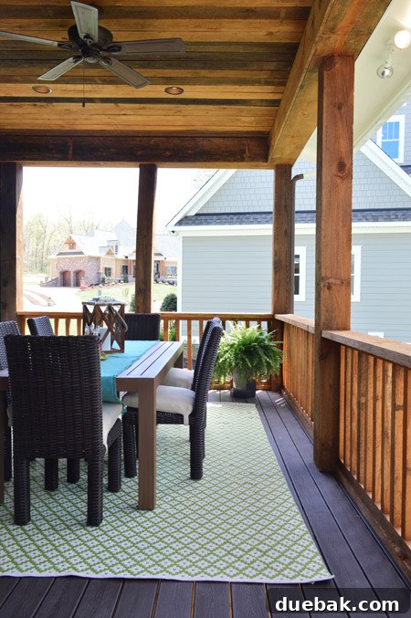 Close-up of the outdoor dining table on the back porch with place settings, a lantern, and a Dash & Albert rug.