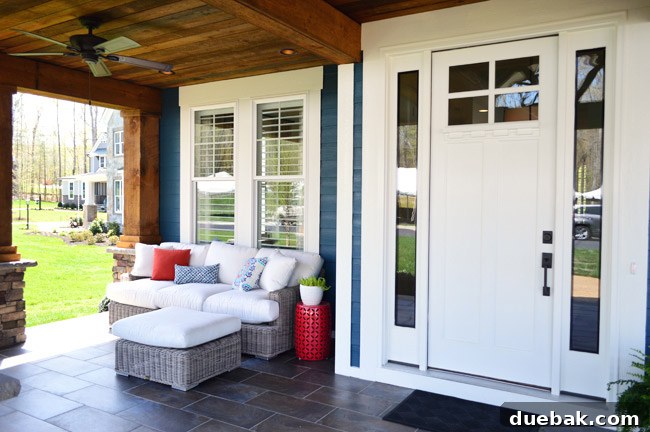 View of the main seating area on the front porch with a sofa, ottoman, and chairs, featuring Arhaus furniture.