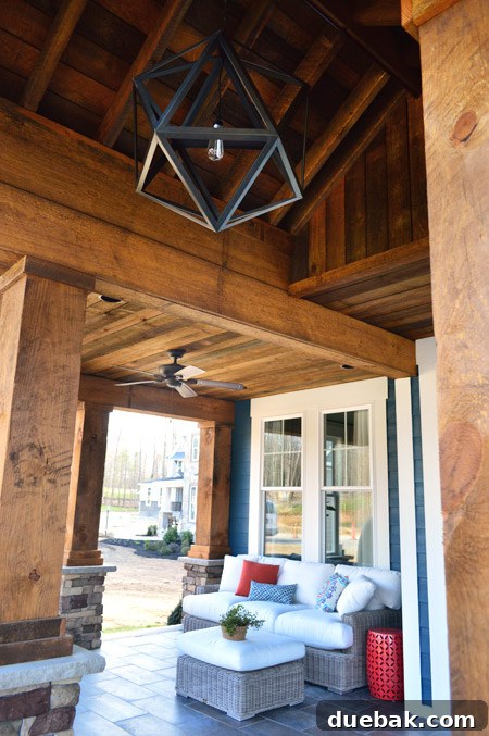 View of the peaked wood ceiling on the front porch, showcasing the light fixture from Restoration Hardware and Hunter fans.