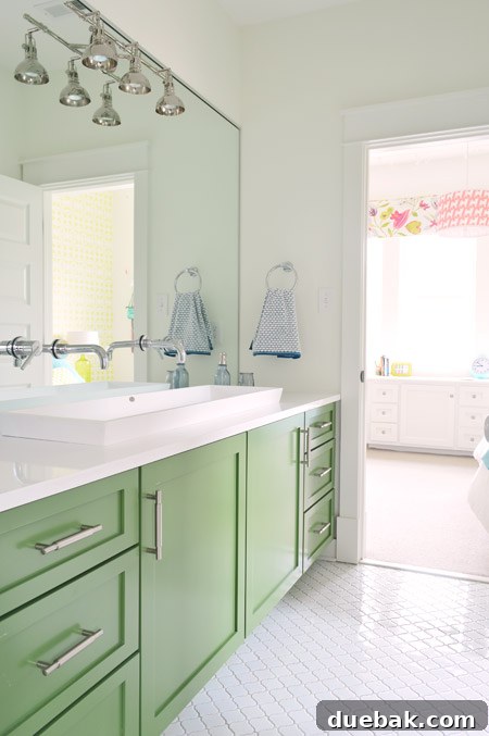 The Family Act 11 Modern Jack-and-Jill bathroom with green vanity and white tiles
