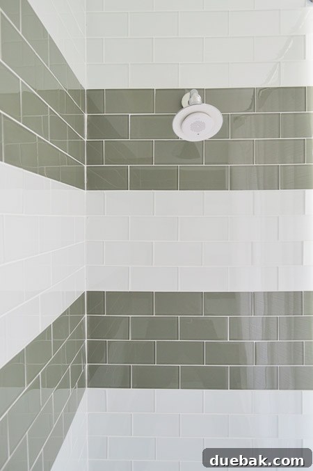 The Family Act 15 Shower with striped glass tiles and a modern showerhead