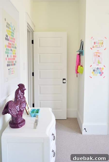 The Family Act 22 Side of a girl's room with art, a dresser, and a customized rail hook