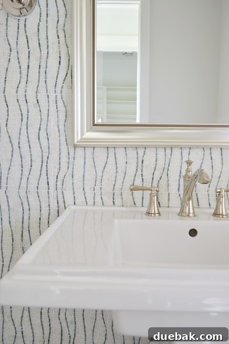 Our Showhouse: Full Video Walkthrough 12 Close-up of powder room sink with faucet, mirror, and sconces
