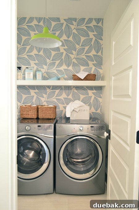 Our Showhouse: Full Video Walkthrough 14 Close-up of laundry room sink area with wallpaper, pendant light, and faucet