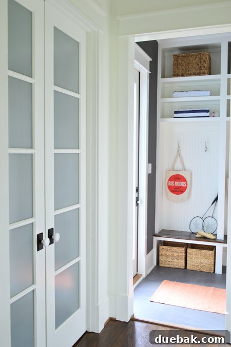 Our Showhouse: Full Video Walkthrough 8 Mudroom with dark walls, white built-ins, and a functional bench