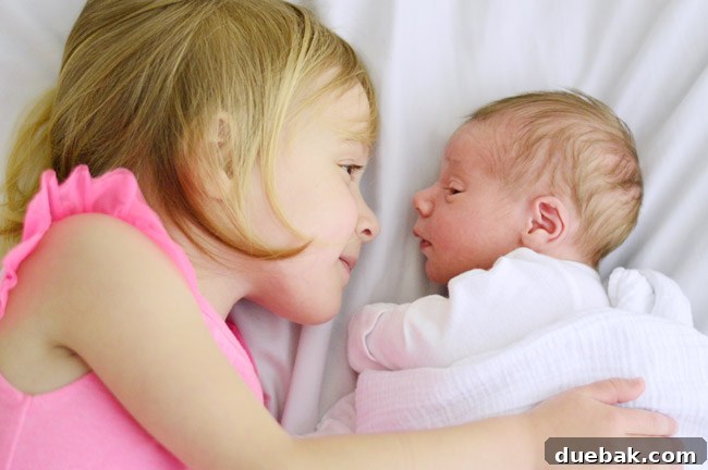 Big Sister And Baby Brother Side-By-Side In Bed