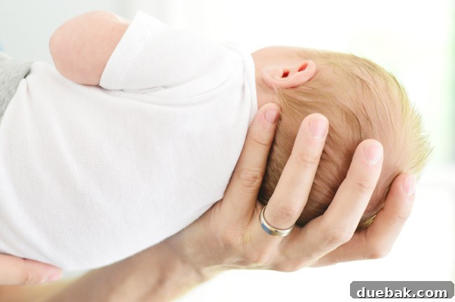 Dad Hand Holding Newborn Head For Birth Announcement Photoshoot