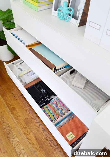 Left side drawers of John's desk, revealing tax documents and backup drives