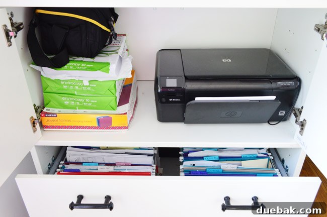 Open Ikea Effectiv cabinet showing printer, paper, and file drawer