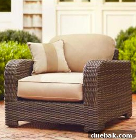 A beige woven outdoor armchair designed to match a contemporary patio sofa, ideal for creating a cohesive outdoor lounge area