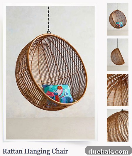 A chic grey hanging egg chair from Anthropologie, featuring a minimalist design suitable for modern outdoor lounge spaces