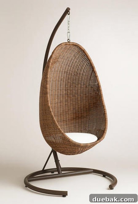 A beautiful woven hanging egg chair with its own stand and a soft cream cushion, seen as a desirable but sold-out item