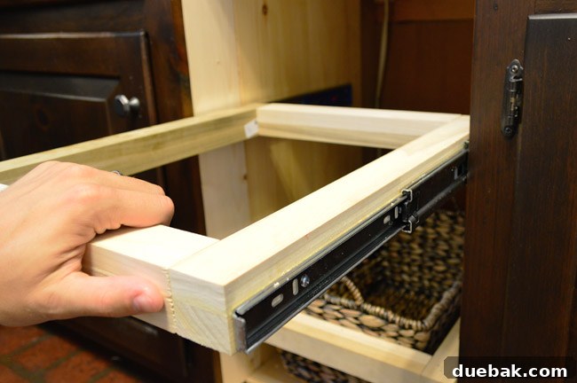 The drawer fully assembled and installed, being tested for smooth, soft-close functionality.