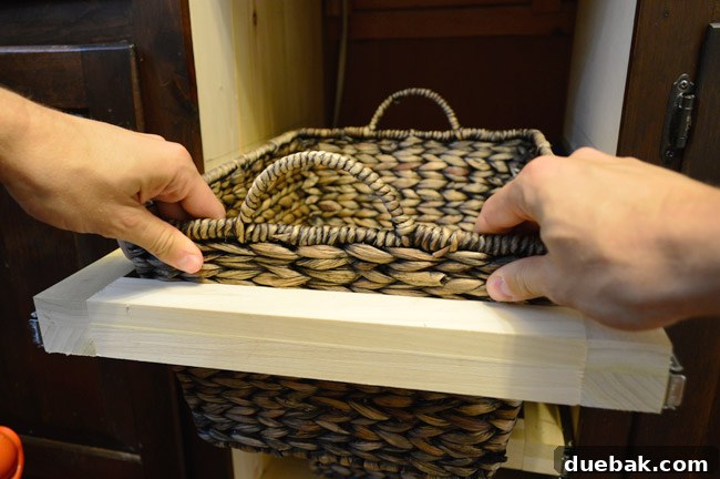 The woven basket neatly placed inside its custom wooden slide-out frame, ready for use.