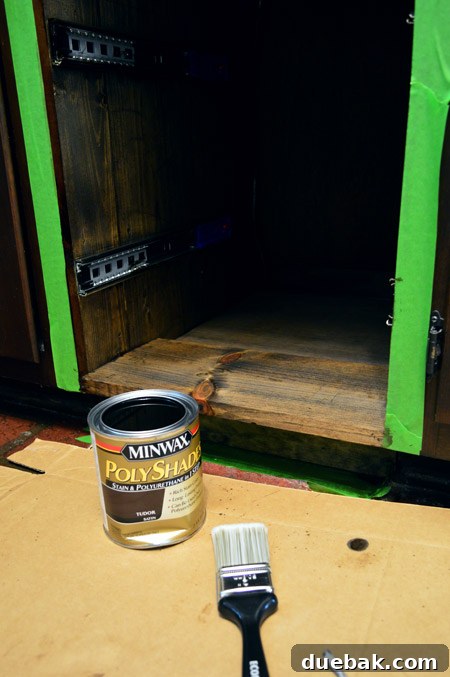 Applying a base coat of Dark Walnut stain to the new wood pieces to deepen their tone.