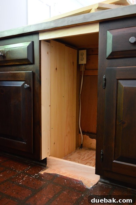 Building out the cabinet sides with scrap wood to create flush surfaces for drawer slide installation.