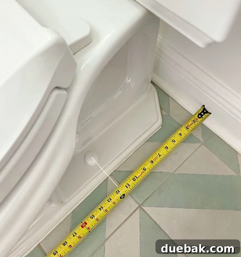 Tape Measure Taking Rough In Measurement By Toilet Bowl