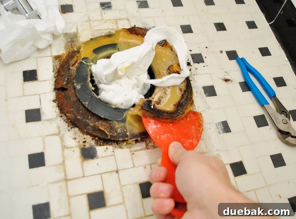 Scraping Old Wax Ring From Bathroom Floor During Toilet Installation