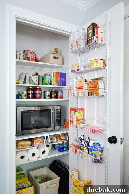Organized pantry with microwave, door storage, and hanging baskets