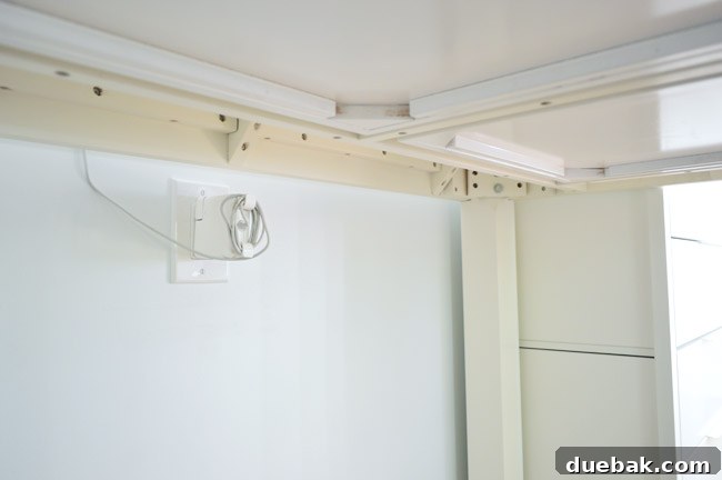 New wall outlet discreetly installed under a desk for hidden cables