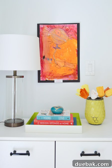 Close-up of a child's colorful monster drawing taped to a wall