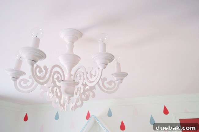 Clara's newly installed, repurposed pink chandelier illuminating her bedroom with a soft glow.