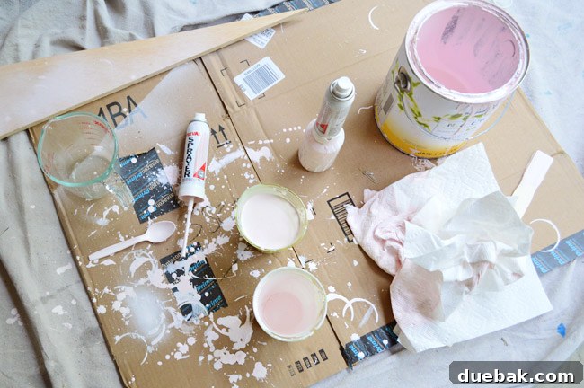 Chandelier being carefully painted a custom pink color with the Preval Sprayer in the garage setup.