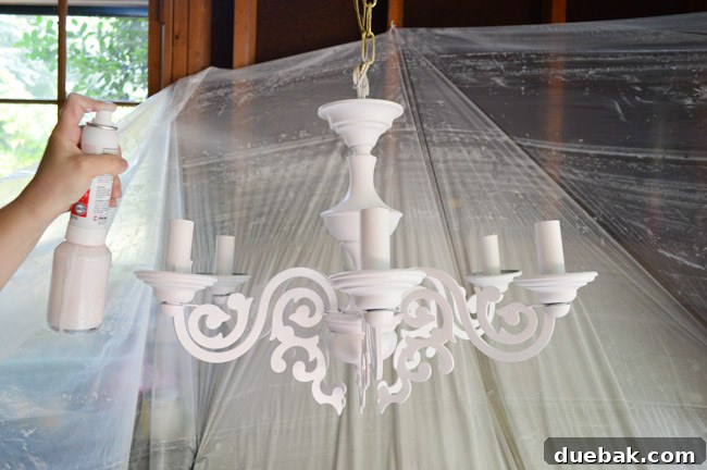 The newly painted pink chandelier, showcasing its smooth finish and custom color, ready for installation.