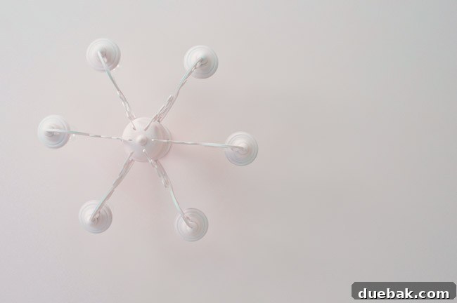 Close-up of the bright, illuminated pink chandelier in Clara's room, showcasing its vibrant new color.