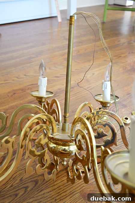 The exposed central threaded rod of the chandelier after all decorative elements have been removed.
