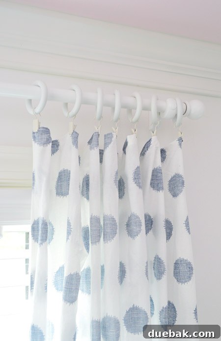 Clara's room with new white wooden curtain rods installed, creating a seamless and lighter appearance above the windows.