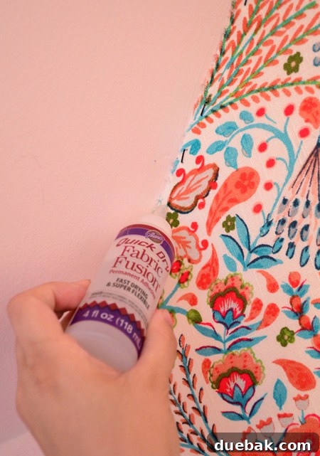 Transform Your Walls with Fabric 13 Applying Aileen's Fabric Fusion glue along the trimmed fabric edge
