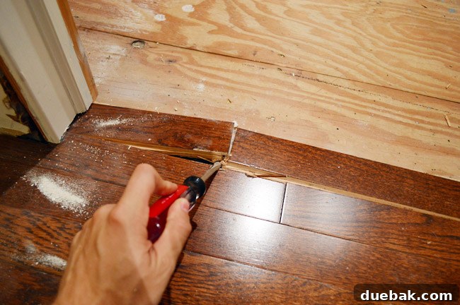 The Ultimate Laundry Room Makeover: From Demolition to Design 11 Detail of removing Elastilon-laid hardwood flooring