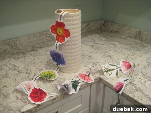 White Cylinder Vase and Garland Representing a Year of Flowers Gift