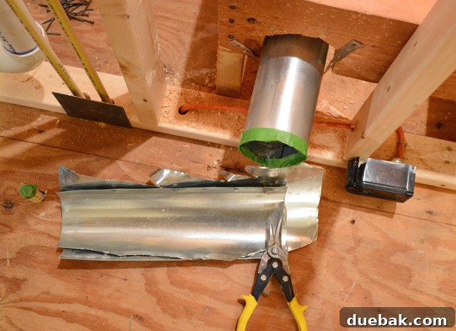 Routing New Laundry Exhaust Systems 12 Trimming dryer vent pipe with metal snips and applying painter's tape for safety on the raw edge during renovation