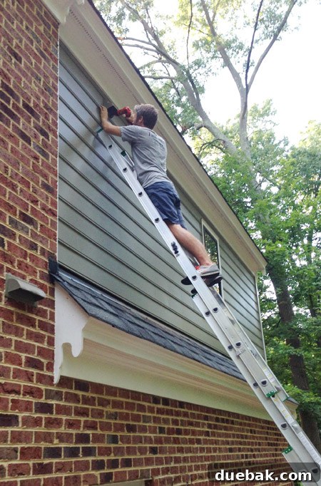 Routing New Laundry Exhaust Systems 18 Securing new dryer vent cap to siding, illustrating strategic placement choice to avoid lint buildup on the roof below