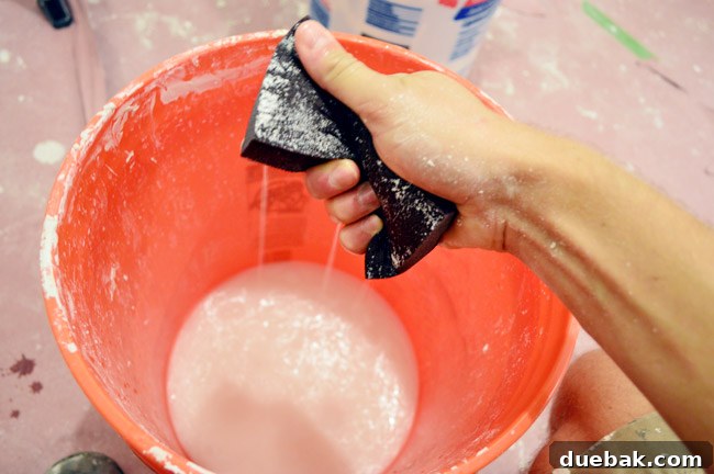 squeezing water out of sanding block like a sponge into a bucket