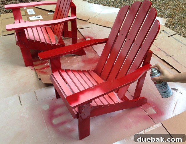 Spraying a red Adirondack chair with Rustoleum Gloss Protective Enamel