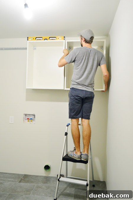 Mastering Ikea Cabinet Installation 19 First IKEA cabinet frame hung on the metal rail