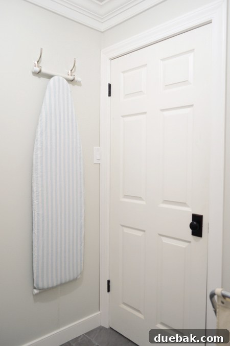 Ironing board stored vertically on wall hooks