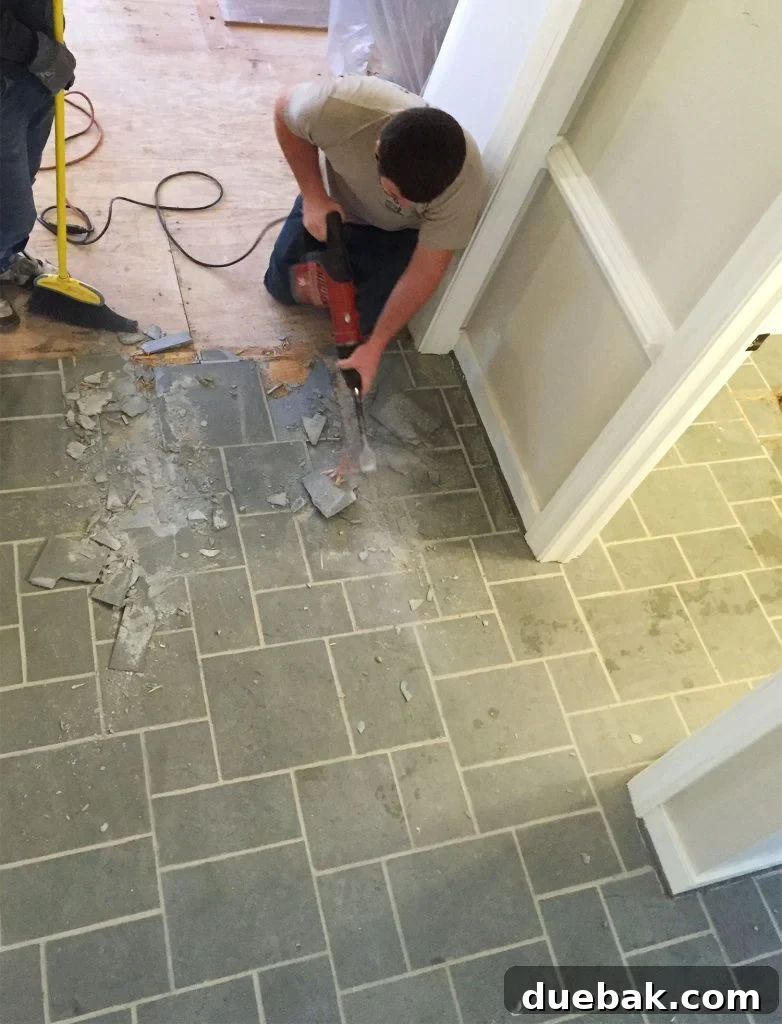 Revitalizing Hardwood Floors The Beginner's Handbook 5 Man efficiently using a demolition hammer to remove a slate floor during a complex renovation