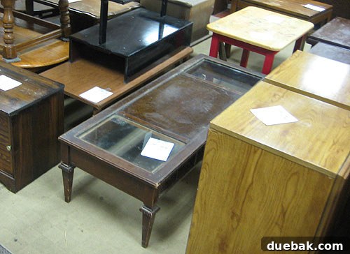 Close-up of a sleek, low-profile coffee table with glass inserts found at Diversity Thrift