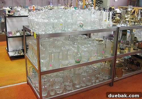 A collection of various glass vases, most priced at a dollar or less, displayed at Diversity Thrift