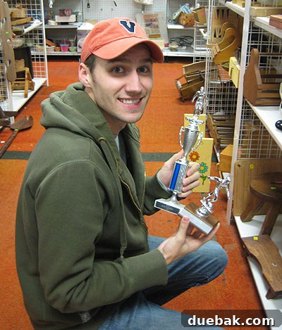 A collection of various bowling trophies for sale at Diversity Thrift, ready for upcycling