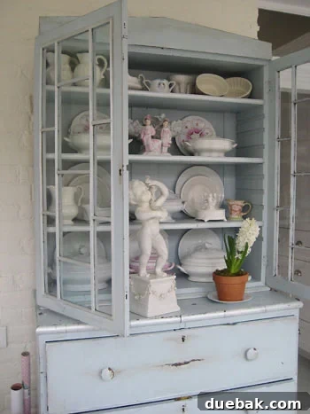 Sunroom hutch painted and distressed, filled with white pottery